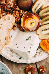 Flatley cheese plate with figs. Snacks for the company. Set of cheeses on a plate with honey and nuts.