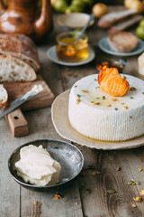Fresh homemade cheese with dried apricot. Still life with hands, the chef prepares dishes. A circle of curd cheese on a plate.