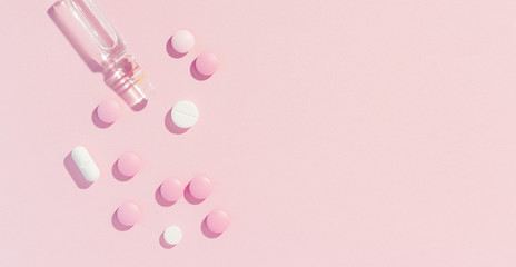 pills on pink paper background, long banner