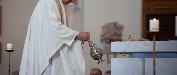 The priest of the Roman Catholic Church censers censer during the Holy Mass in the church. Feast of the Body of the Lord