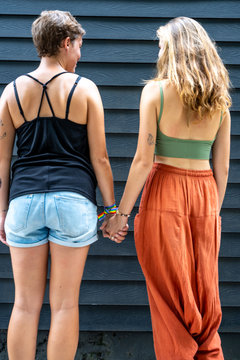 Vertical photo of two lesbian girls holding hands in the street