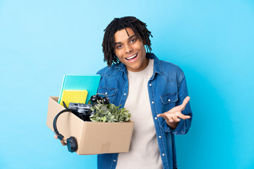 Young African American man making a move while picking up a box full of things with shocked facial...