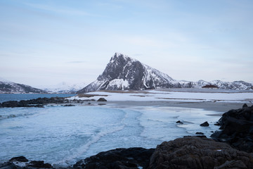 Scenic view to beautiful white sand beach located in Lofoten Islands archipelago in northern Norway. Unique mountain in background. 