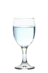 The water from the bottle is poured into a separate glass on a white background. Concept for health