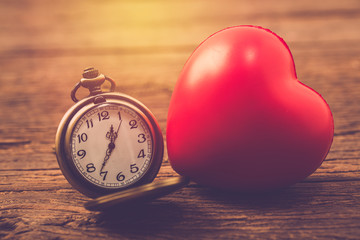 valentine day background red heart with compass on wooden table close up. vintage filter