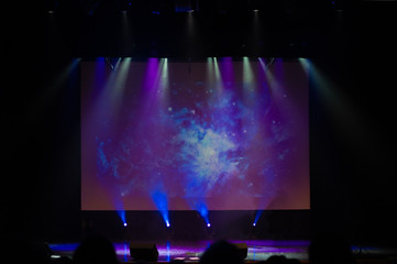 An empty stage of the theater, lit by spotlights and smoke before the performance