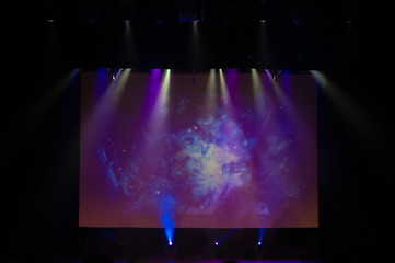 An empty stage of the theater, lit by spotlights and smoke before the performance