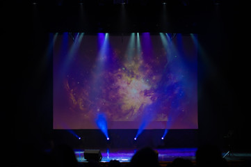 An empty stage of the theater, lit by spotlights and smoke before the performance