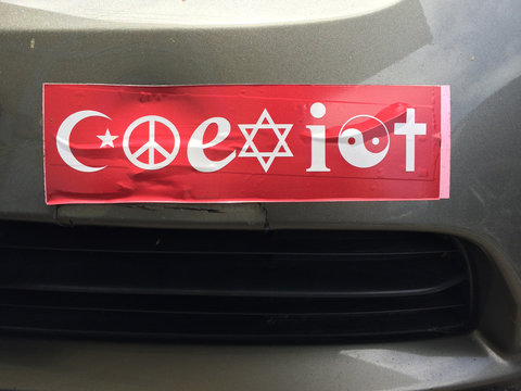 Red Coexist bumper sticker on car parked