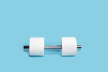 Concept of toilet paper and dumbbell for home quarantine from coronavirus.