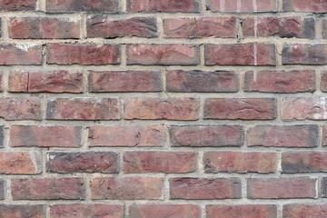 Fragment of the wall of an old building made of baked brick in natural light. Close-up. Texture. Background.