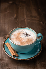 coffee with milk in a ceramic blue cup on a wooden background. Place for text, top view.