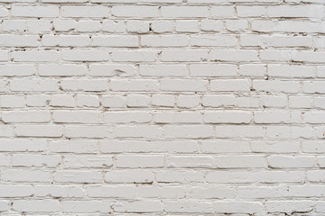 Fragment of a white painted brickwork of a wall of an old building under natural light. Close-up. Texture. Background.