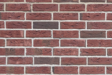 Fragment of the wall of an old building made of baked brick in natural light. Close-up. Texture. Background.