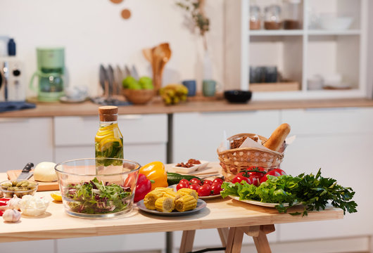 Image of table with vegetables food and drinks on it in the kitchen at home