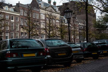 Cityscape of Amsterdam. Dutch city architecture. Modern exterior of buildings. Parking cars.