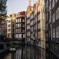 Fototapeta na wymiar Cityscape of Amsterdam. Dutch city architecture. Modern exterior of buildings. Reflection in water of canal. Tourism in Europe.