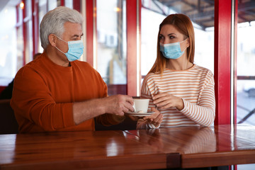 People with medical masks in cafe. Virus protection
