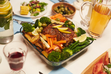 Image of roast meat with potatoes and vegetables served for dinner on the table