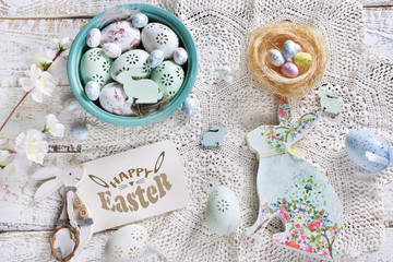 Fototapeta na wymiar easter flat lay with colorful eggs, decors and paper card with greeting text