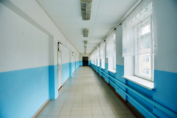 a public school, a long empty corridor with blue walls. The concept of quarantine