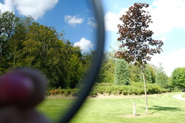 Close up of a part of a polarizer filter, show the difference with and without this filter, landscape background