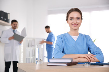 Obraz premium Portrait of female doctor at table in modern clinic