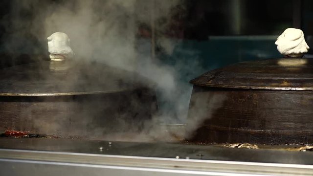 Traditional iron cooking pot boiling beef bone broth at Korean restaurant