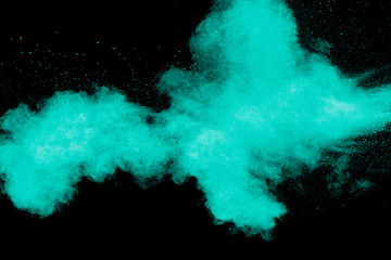 Green color powder explosion cloud on black background.Green dust splash.