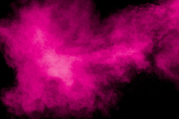 Obraz na płótnie Canvas Abstract pink dust explosion on black background. Freeze motion of pink powder splash.