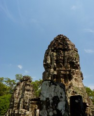 Ruins of Angkor, face tower of Bayon temple against blue sky, Angkor Wat, Cambodia
