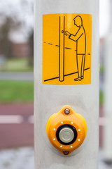Button and sign at a crosswalk for a safe pedestrian crossing