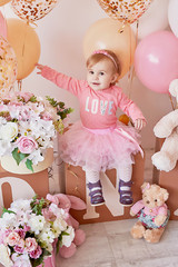 Smash cake party. Little cheerful birthday girl with first cake. Happy infant baby celebrating his first birthday. Decoration and photo zone for first year. One year baby celebration. Pink decor.