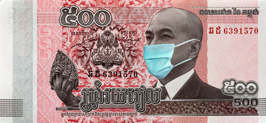 Coronavirus in Cambodia. Quarantine and global recession. 500 Riel banknote with a face mask against infection. Global economy hit by corona virus covid19 outbreak and pandemic.  Coronavirus affects g