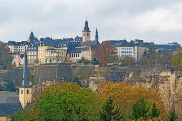 Fototapeta na wymiar Detail of famous Luxembourg city line in November with Saint Michael Cathedral and yellow autumn trees, Luxembourg.