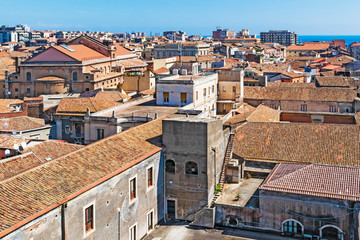 Naklejka premium Aerial skyline panoramic view of city of Catania in September, old town featuring brown, ochre and yellow roofs. Sicily, Italy. Vintage or travel background.