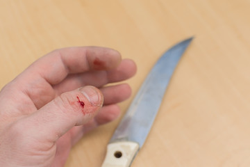 a clot of a drop of blood on the finger of a hand that was accidentally cut with a knife