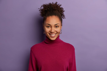 Portrait of happy smiling Afro American woman has joyful expression, glad to be promoted and...