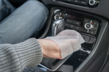 Man cleaning front dashboard of a car using antivirus antibacterial wet wipe (napkin) for protect himself from bacteria and virus.
