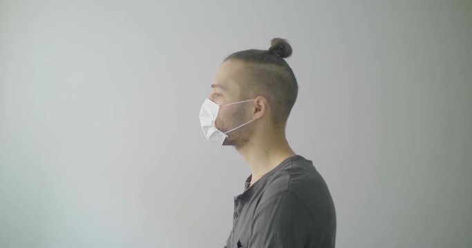Young Caucasian Man with Blond Hair  is Singing and Dancing Using a Disposable Face Mask for Covid-19, Cough, Flu, Virus, Viral Protection. 