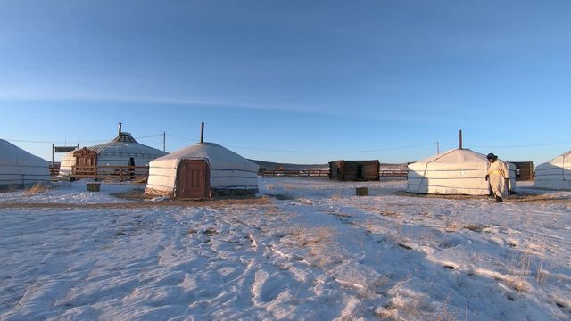 Nomadic Man Wearing Del Walks Past Yurt Homes. Khatgal, Mongolia.