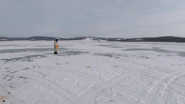 Man Wearing Del Walks From Left To Right Across Frozen Lake Khovsgol, Khatgal, Mongolia