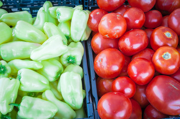 Jalapeno and red tomatoes on black plastic food crate at farmer market in Washington, America