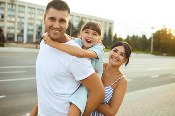 Happy smiling family walking on the street.