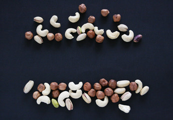 Fototapeta na wymiar Nuts on black background, top view with copyspace. Assorted mixed nuts isolated on dark table.