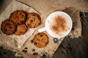 Top view cappuccino coffee with cookies on the wooden table