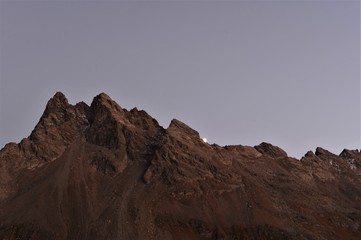 Silhouette of mountains in the Swiss mountain landscape with the moon rising
