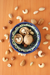 Nuts in bowl on white background, top view with copyspace.  Assorted mixed nuts  isolated on table.