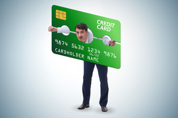 Businessman in credit card burden concept in pillory