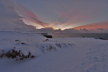 Morning mood on the coast in Iceland with a snow cliff